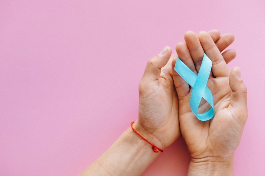 hand holding a blue ribbon
