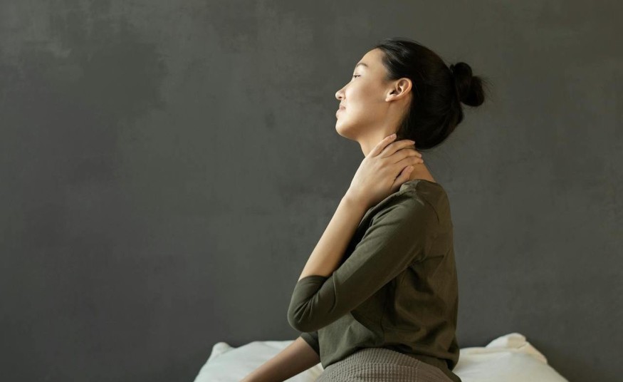 girl in gray sitting on bed