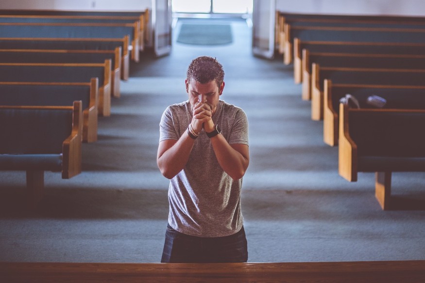 man praying inside church